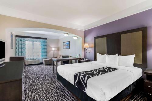 a hotel room with a large bed and a desk at La Quinta by Wyndham Fultondale Birmingham North in Fultondale