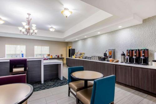 a restaurant with tables and chairs and a counter at La Quinta by Wyndham Fultondale Birmingham North in Fultondale