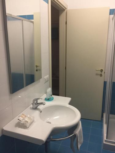 bagno con lavandino bianco e specchio di Albergo La Pineta a Cingoli