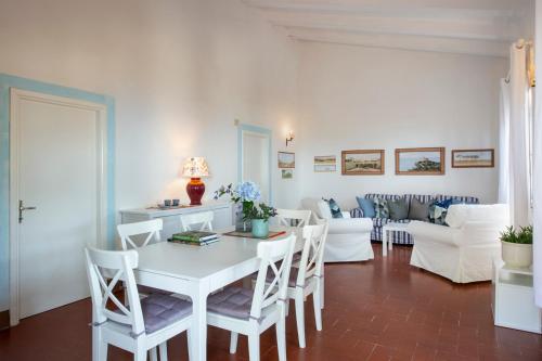 Tenuta Le Rocchette في Rocchette: غرفة معيشة مع طاولة وكراسي بيضاء