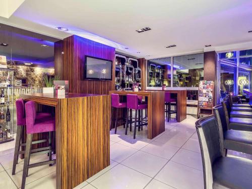 a bar in a restaurant with purple bar stools at Mercure Gdańsk Stare Miasto in Gdańsk