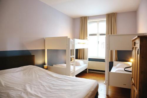 een slaapkamer met 2 stapelbedden en een raam bij Vakantiewoning Villa Elena in Nieuwpoort