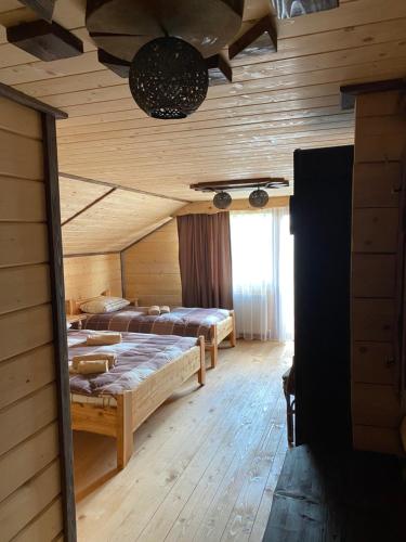ヴェルホヴィナにあるHotel Gerdan Verkhovinaのログキャビン内のベッドルーム1室(ベッド2台付)