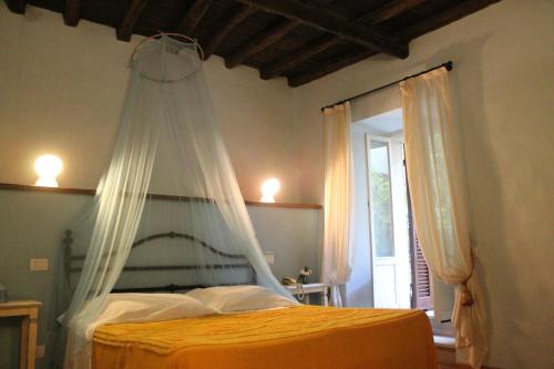 a bedroom with a bed with a mosquito net at Ospitalità Collicola in Spoleto