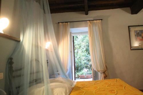 a bedroom with a canopy bed and a window at Ospitalità Collicola in Spoleto