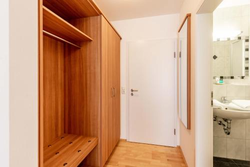 ein Badezimmer mit einer Holztür und einem Waschbecken in der Unterkunft Gasthaus Hotel Ostermeier in Attenkirchen