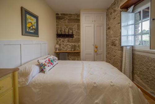 a bedroom with a large white bed with a window at Aldeade in Ferreira de Panton