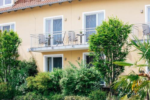 a building with a balcony and trees in front of it at Gasthaus Hotel Ostermeier in Attenkirchen