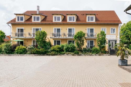 a large yellow house with a tile roof at Gasthaus Hotel Ostermeier in Attenkirchen