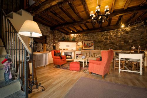 a living room with red chairs and a stone wall at Aldeade in Ferreira de Panton