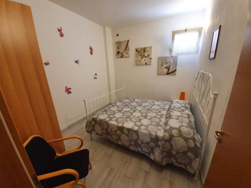 een kleine slaapkamer met een bed en een stoel bij King Apartment in Torino di Sangro