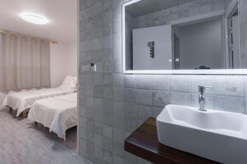 a bathroom with a sink and a mirror and a bed at Guilin Flowers Inn in Guilin