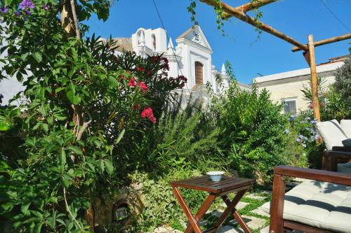 a garden in front of a house with flowers and a table at Le Cantinelle in Anacapri