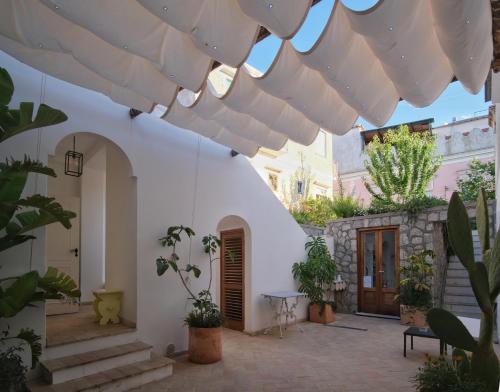 a courtyard with a white building with plants at Le Cantinelle in Anacapri