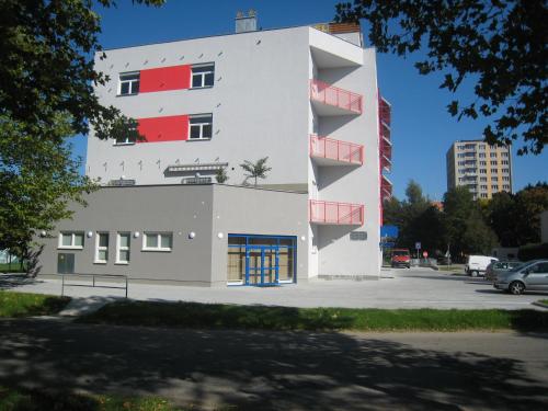 a tall white building with a blue door at Sport Hotel České Budějovice in České Budějovice