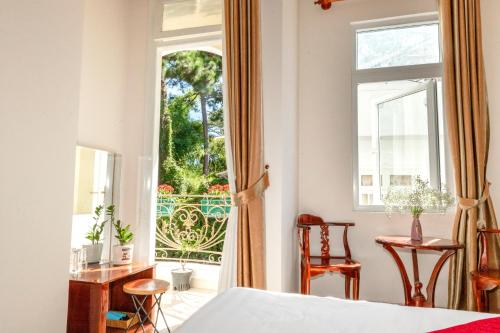 una camera con letto e finestra aperta di Conico Đà Lạt Hotel a Da Lat