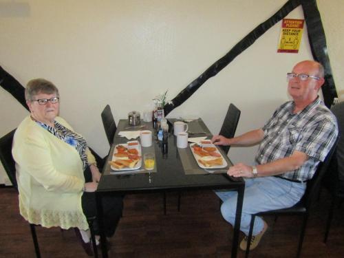 布莱克浦Alderley Hotel Blackpool的两个人坐在餐桌上吃着食物