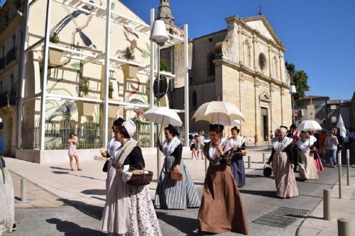 a group of women walking down a street with umbrellas at Duplex au Coeur de Lunel in Lunel