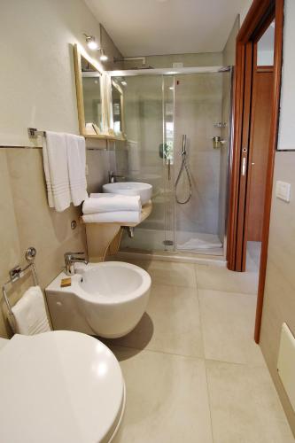 a bathroom with two sinks a toilet and a shower at B&B I Graniti Sardi in Villasimius