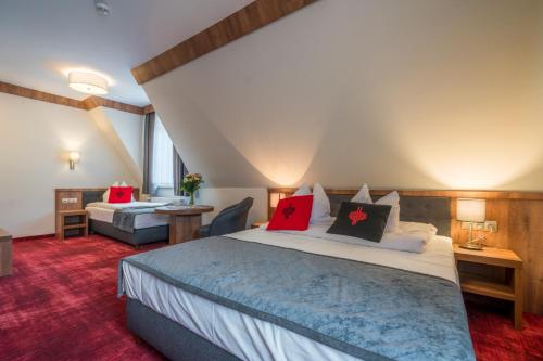 a bedroom with a large bed with red pillows at Magnolia in Zakopane
