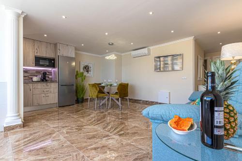 ein Wohnzimmer mit einem blauen Sofa und einer Küche in der Unterkunft Costa Paradise - BEACHFRONT APARTMENT in Fuengirola