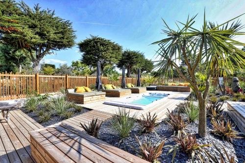 un jardín con piscina y terraza de madera en Domaine Le Sherwood en Notre-Dame-de-Monts