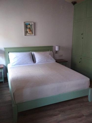 a bedroom with a bed with a green headboard at Argjiro Traditional in Gjirokastër