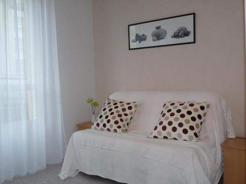 a white bed with two pillows in a room at Sphinx Résidences - Tempologis Mémorial in Caen