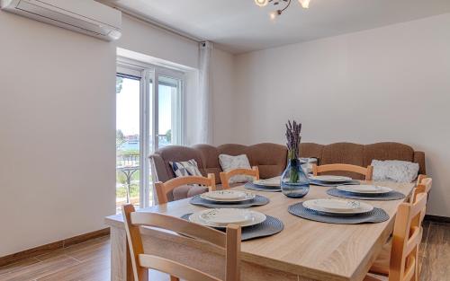 uma sala de jantar com uma mesa de madeira e cadeiras em Villa Umag Seafront em Umag
