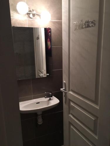 a bathroom door with a sink and a mirror at Duplex au Coeur de Lunel in Lunel