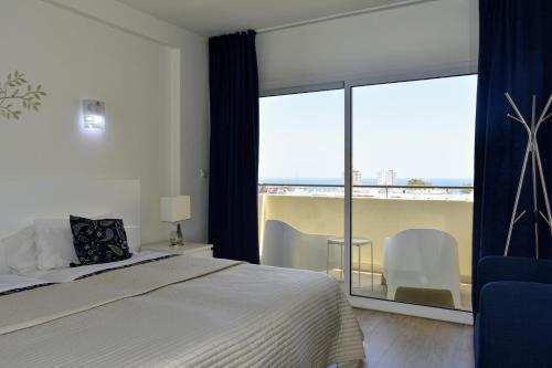 - une chambre avec un lit et une grande fenêtre dans l'établissement Playa Flores - Vistas al Mar, à Torremolinos