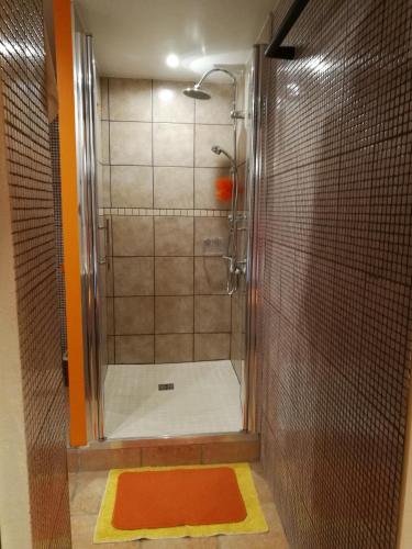 La salle de bains est pourvue d'une cabine de douche avec un matelas orange. dans l'établissement Le Mas Des Sorcières - Maison d'hôtes, à Valréas