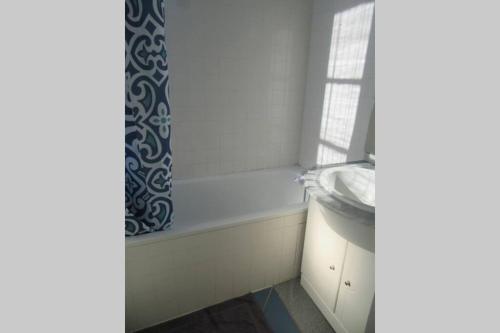 une salle de bain avec un lavabo et un rideau de douche dans l'établissement appartement 60m2 dans quartier historique, à Rochefort