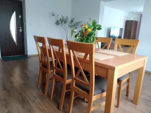 a wooden dining room table with chairs and a vase of flowers at RAMAR in Bodzentyn