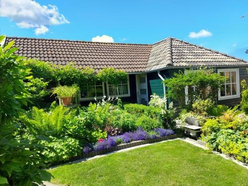 a garden in front of a house with flowers at Holiday Home Canal View in Alkmaar