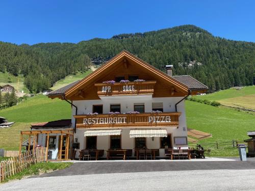 a building with a restaurant on a hill at Jausenstation Saege in Riva di Tures