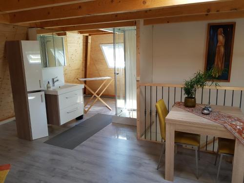 a kitchen and dining room with a table and a refrigerator at De Loft in Zuid-Scharwoude