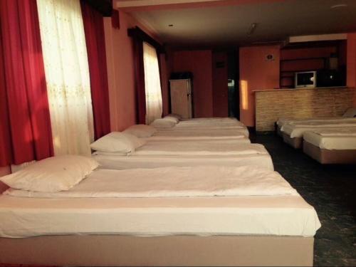 a row of beds lined up in a room at Motel California in Mărtineşti