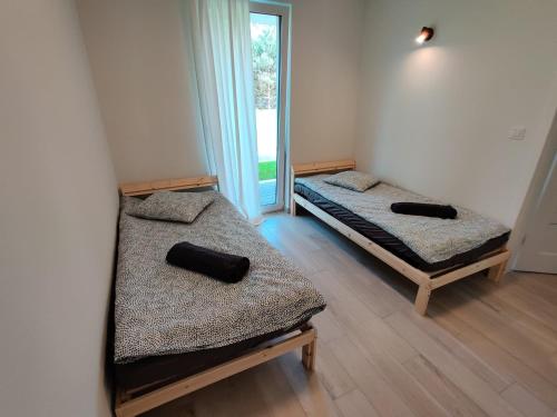 dwa łóżka w pokoju z oknem w obiekcie Ostrowo Plaza w Ostrowie