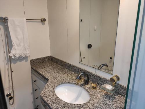 a bathroom with a sink and a mirror at Condomínio Metropolitan - Centro de Brasília A216A in Brasilia