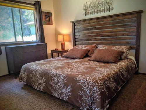 a bedroom with a large bed with a wooden headboard at The Quail's Nest Retreat in Point Reyes Station