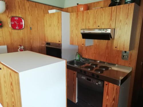 eine Küche mit einem Herd und einem Kühlschrank in der Unterkunft Vetrate sul bosco in Marilleva