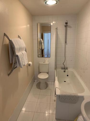 a bathroom with a tub and a toilet and a sink at Broughton Craggs Hotel in Cockermouth