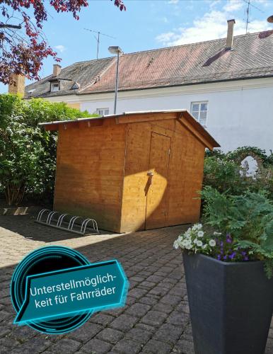 ein Holzspielhaus im Hinterhof eines Hauses in der Unterkunft Gästehaus Reisinger in Straubing
