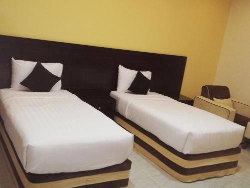 dos camas sentadas una al lado de la otra en una habitación en Alsafa Hotel, en Al Buraymī