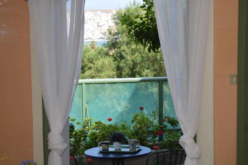 a window with white curtains and a table with a view at Bellevue Apartments in Sitia