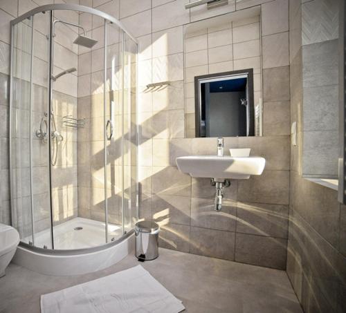a bathroom with a sink and a shower and a toilet at Olympic - Old Town in Gdańsk