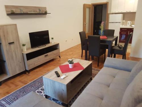 un soggiorno con divano, TV e tavolo di Apartman Jovanka 2 a Trebinje