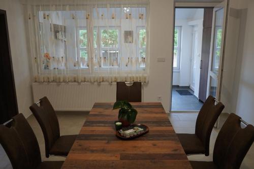 una sala da pranzo con tavolo e sedie in legno di Lali Vendégház ad Ásványráró