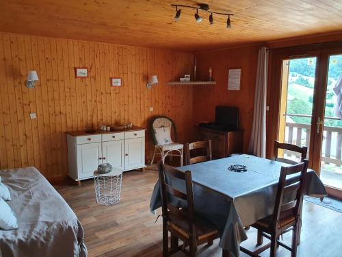 a room with a table and chairs and a kitchen at L'Edelweiss in Aillon-le-Jeune
